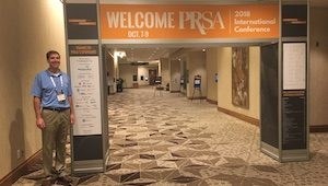 Ryan Johnson standing in front of PRSA Conference welcome sign