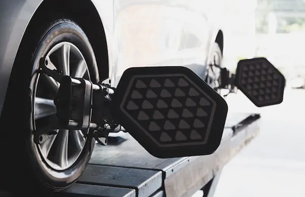 Free Alignment with Purchase of 4 Tires Mechanics Working on an alignment for a Porsche