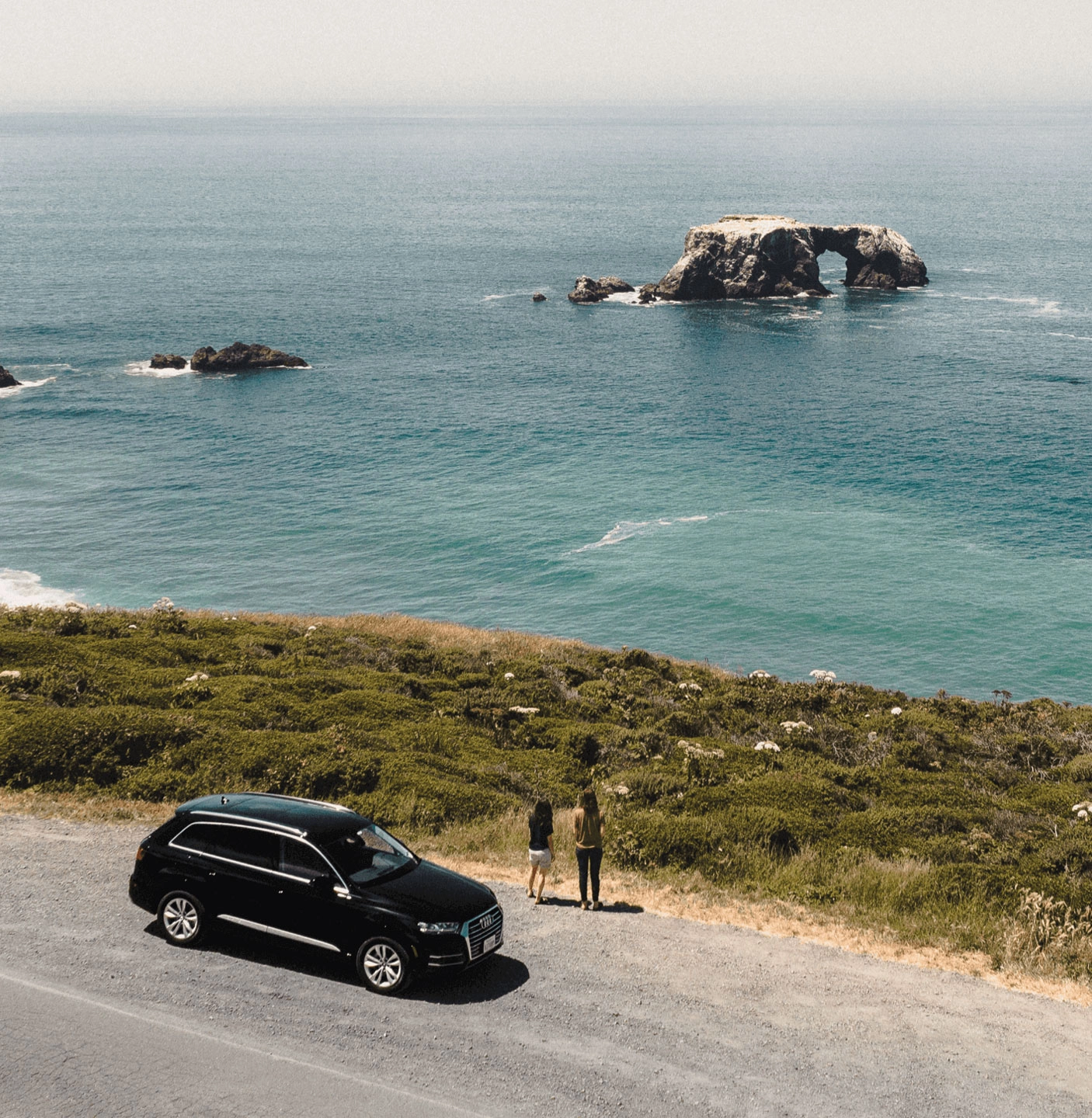 A couple at a beach with a black Audi