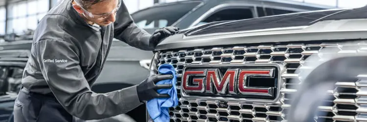 GMC Certified Service Technician Works Under Hood of Vehicle