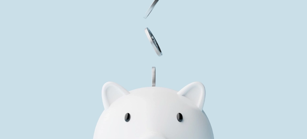 White Piggy Bank with coins dropping in