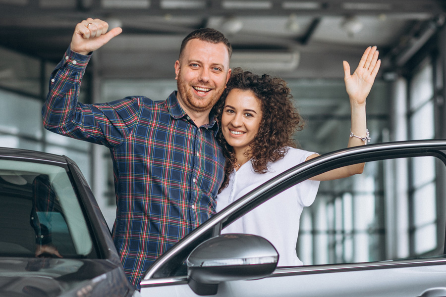 Young family buying a car in a car showroom