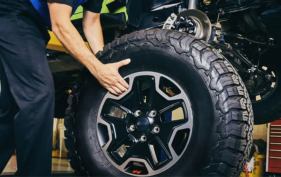 Jeep Wave Worry-Free Maintenance An image of a tire being put on a car at a service shop.