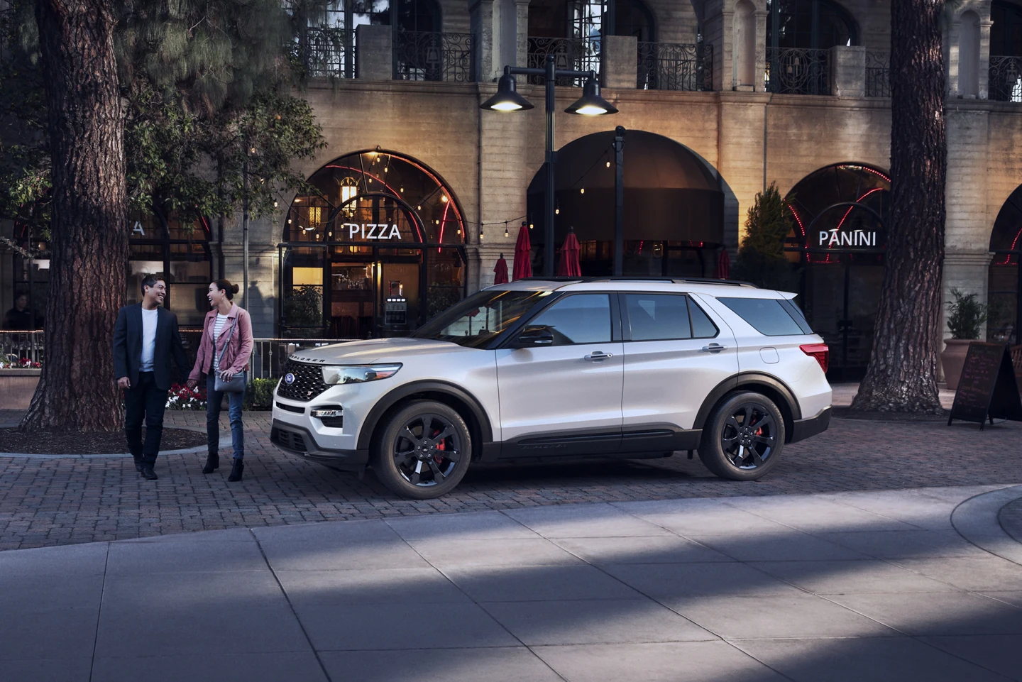 2022 Ford Explorer for sale in Madison, WI Two people walking by a white Ford Explorer