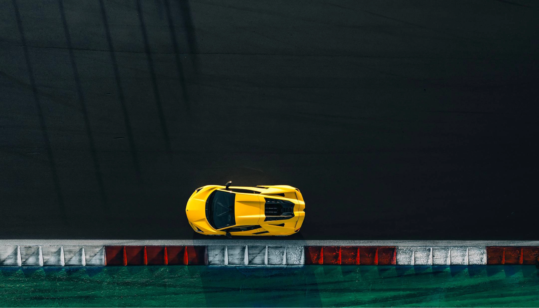 Lamborghini Revuelto parked on side of race track at a birds eye view