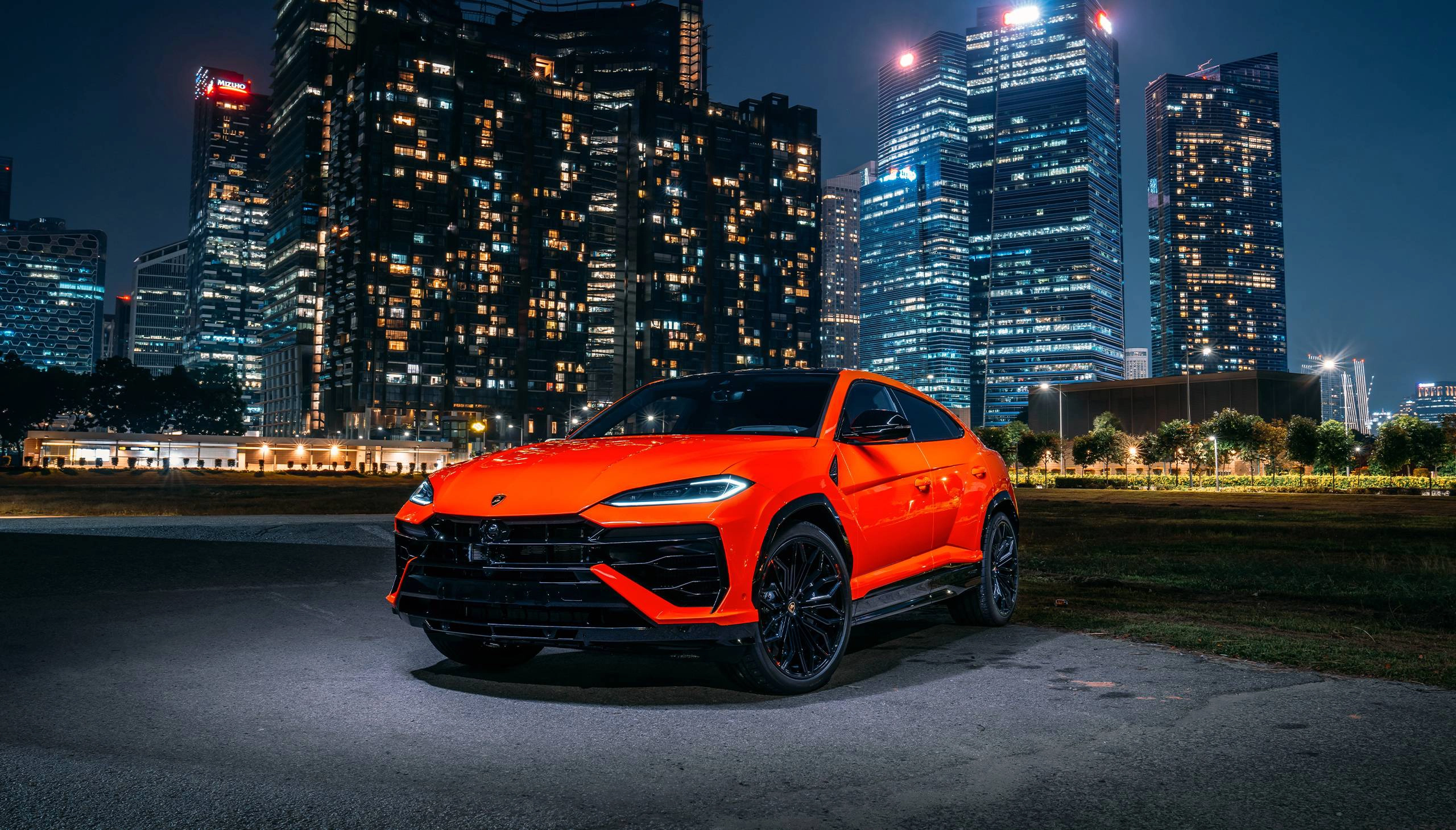 Lamborghini Urus parked in front of city skyline