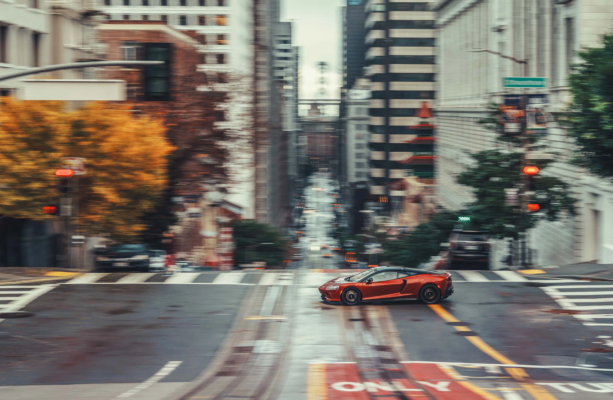 Photo of a McLaren driving through a city street.
