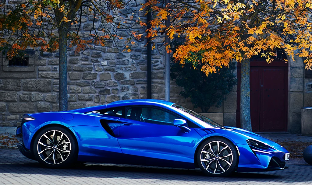 Photo of a McLaren parked by a house.