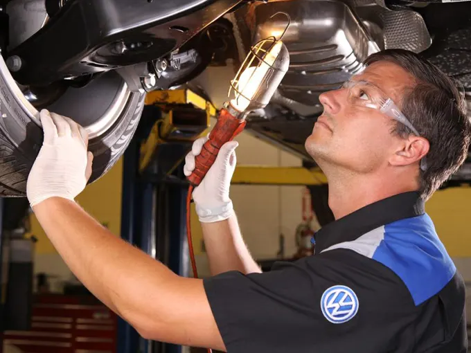 VW service tech inspecting vehicle