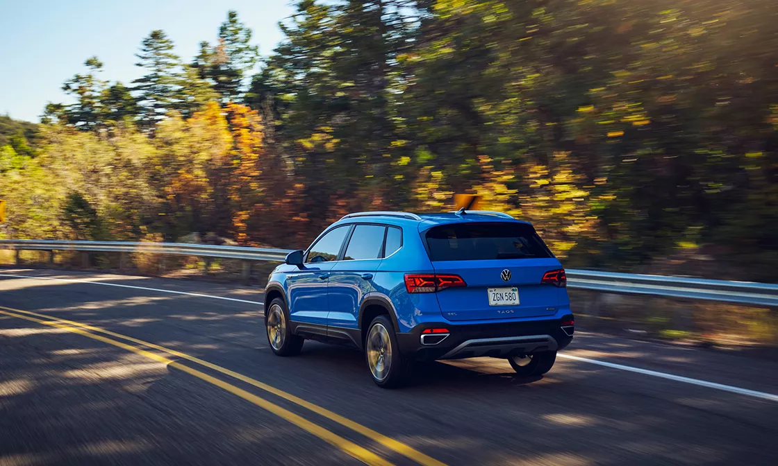 2022 Volkswagen Taos Exterior view of blue Taos driving outside on a sunny day