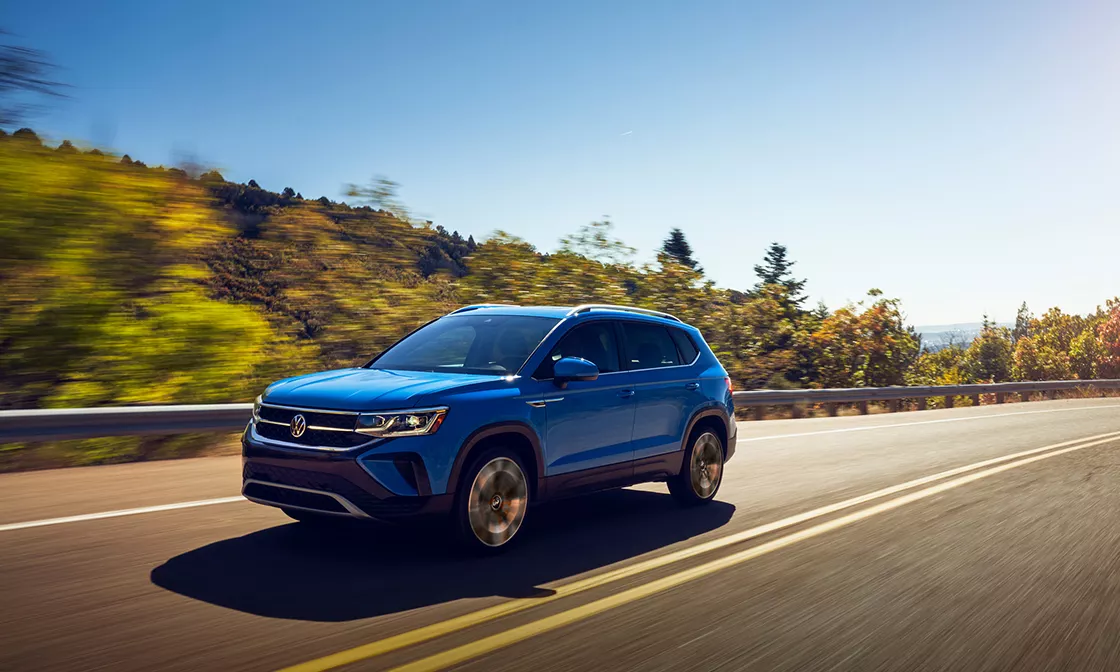 2022 Volkswagen Taos Exterior view of blue Taos driving outside on a nice day