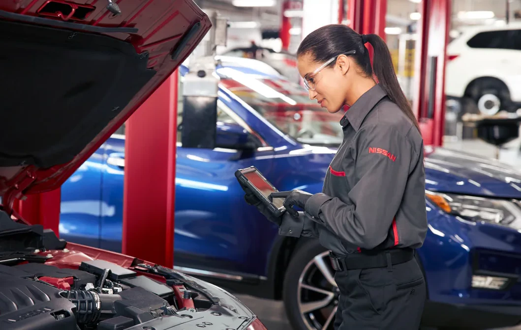 Female Nissan technician working on a Nissan engine