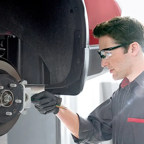 Nissan Service Coupons Nissan Service Technician performing brake service