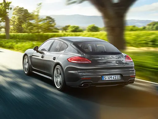Porsche Financial Services Gray Porsche driving on a sunny day