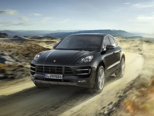 Roadside Assistance Black Porsche driving on a dirt road in the dessert