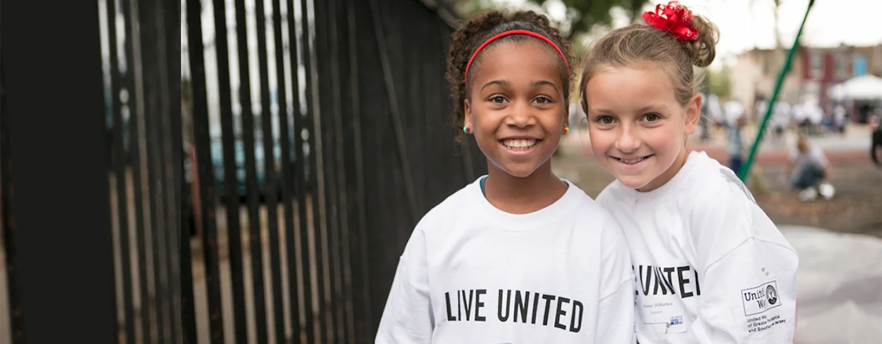 Two little girls wearing Live United t-shirts
