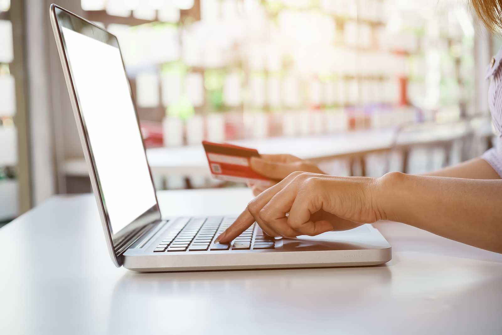 person using laptop with credit card in hand