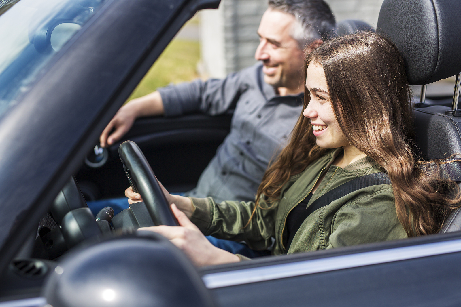 teenager driving with her parent in preowned vehicle