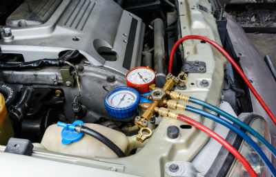 mechanic recharging vehicles air conditioning