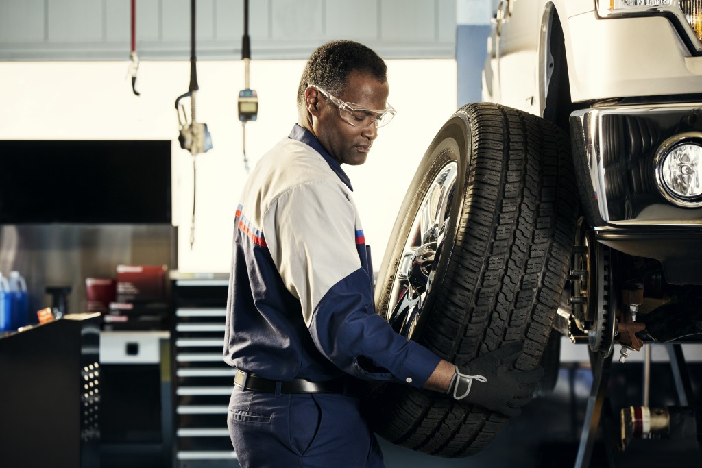 Certified Ford technician performing a tire rotation