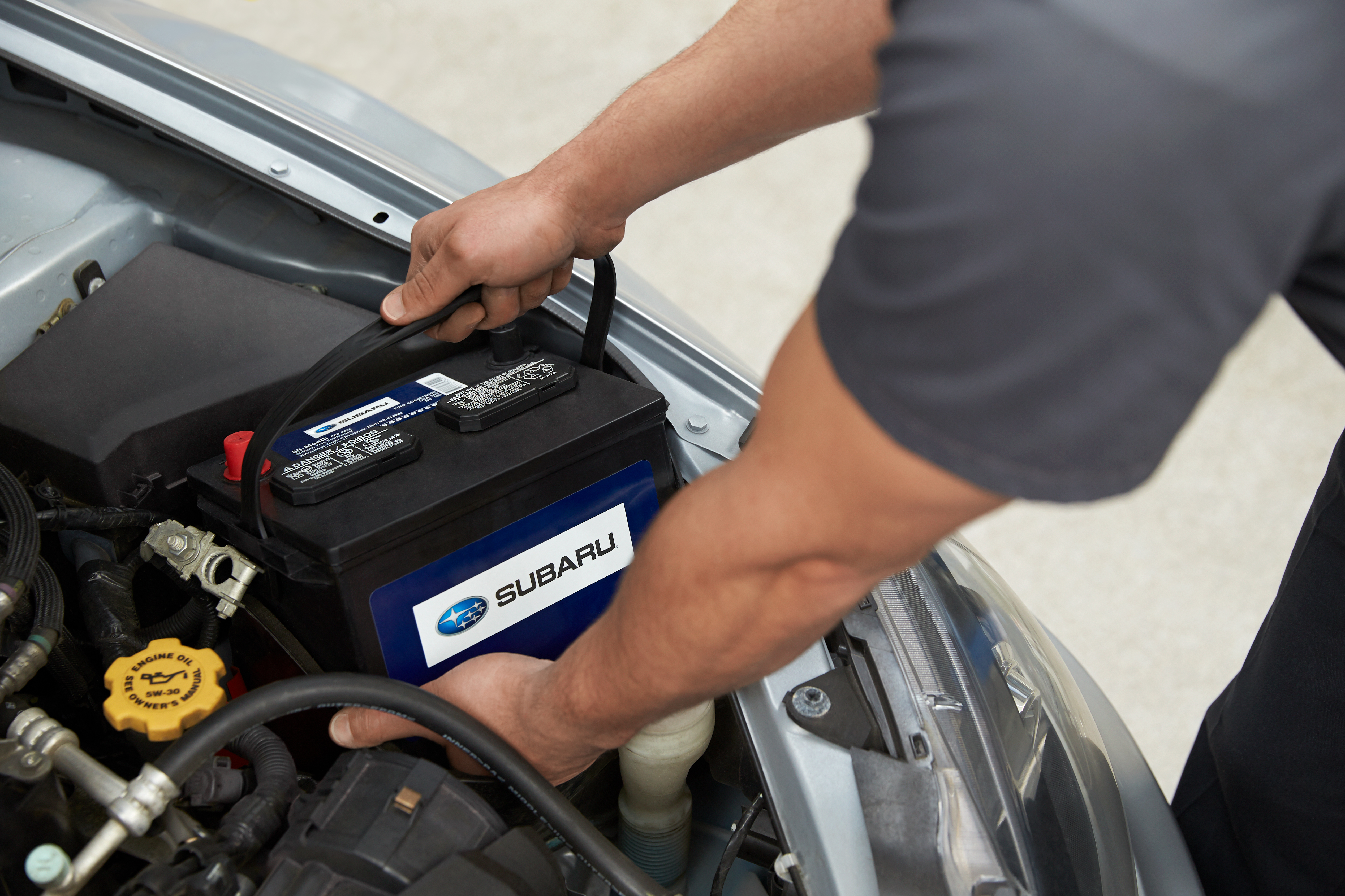 subaru mechanic installing a battery in a vehicle