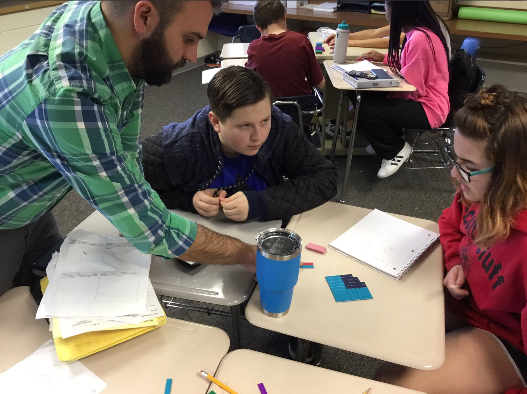 Tyler works with two students in his  math class using visuals.