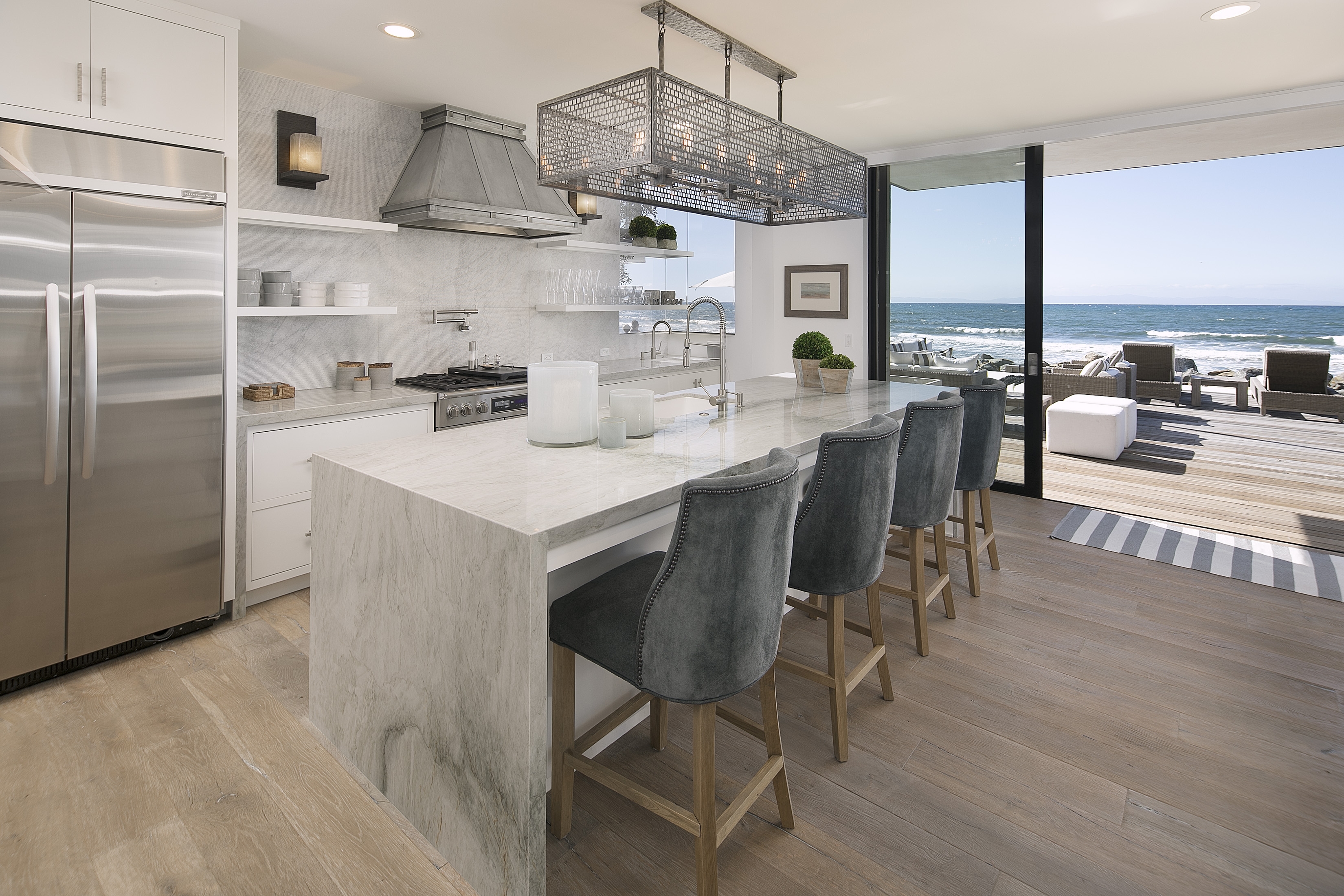 open kitchen with bar seating overlooking deck and ocean