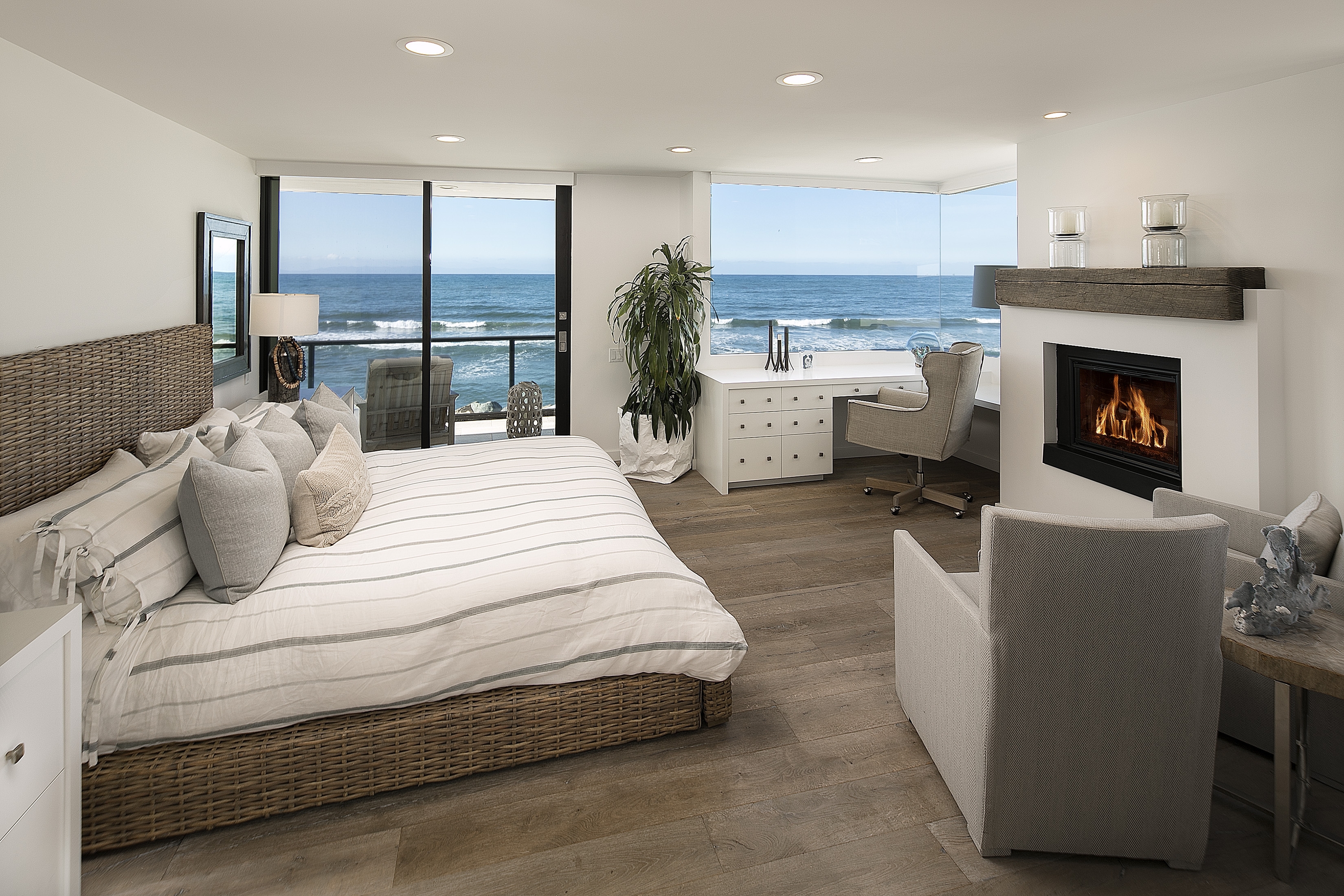 bedroom with fireplace and view of ocean