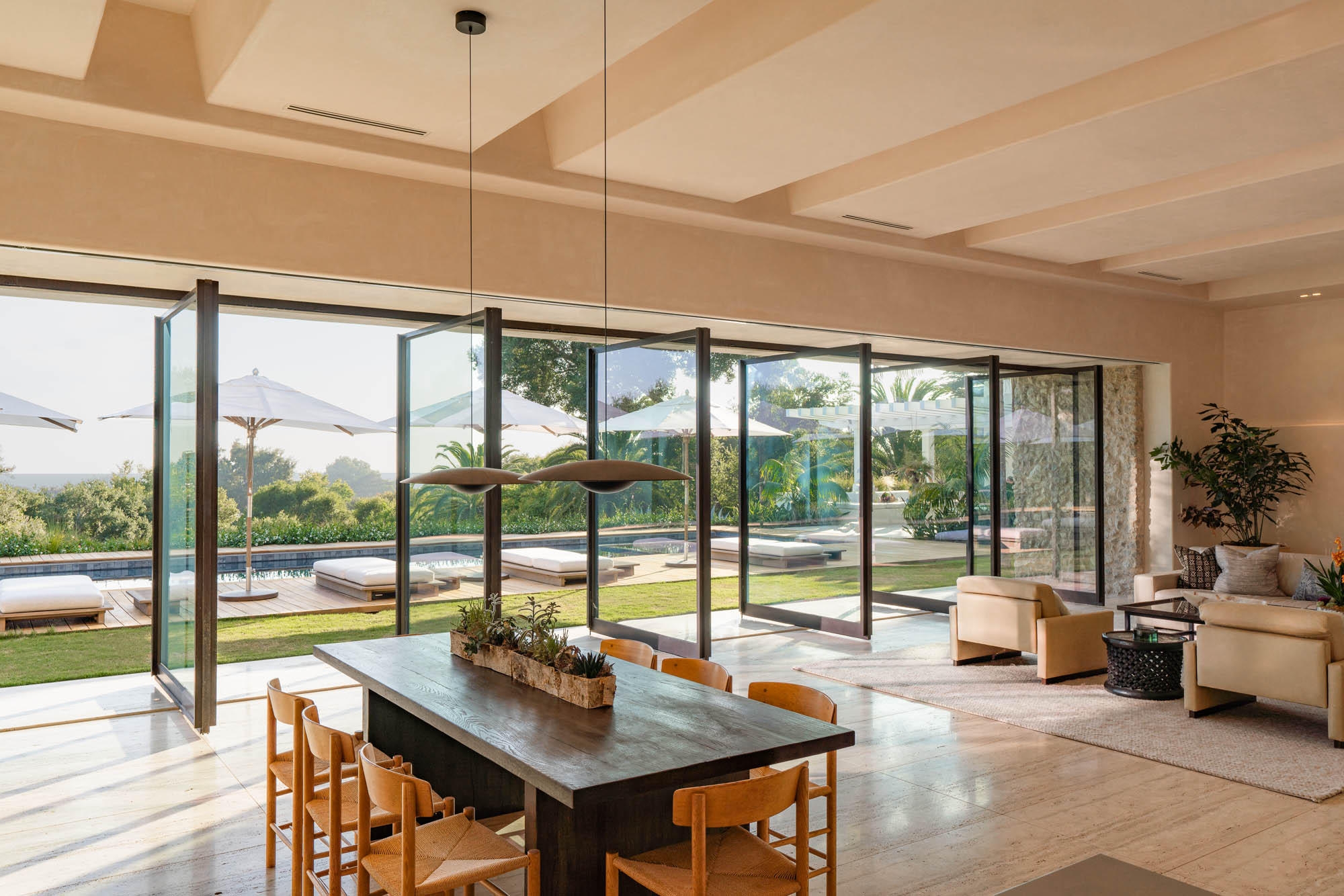 open living and dining room with large open glass doors