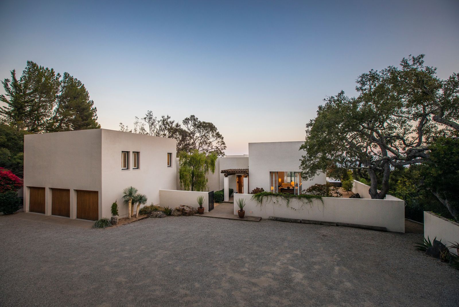 A modernist Montecito home with stark elements such as geometric white stucco walls against a deep blue sky.