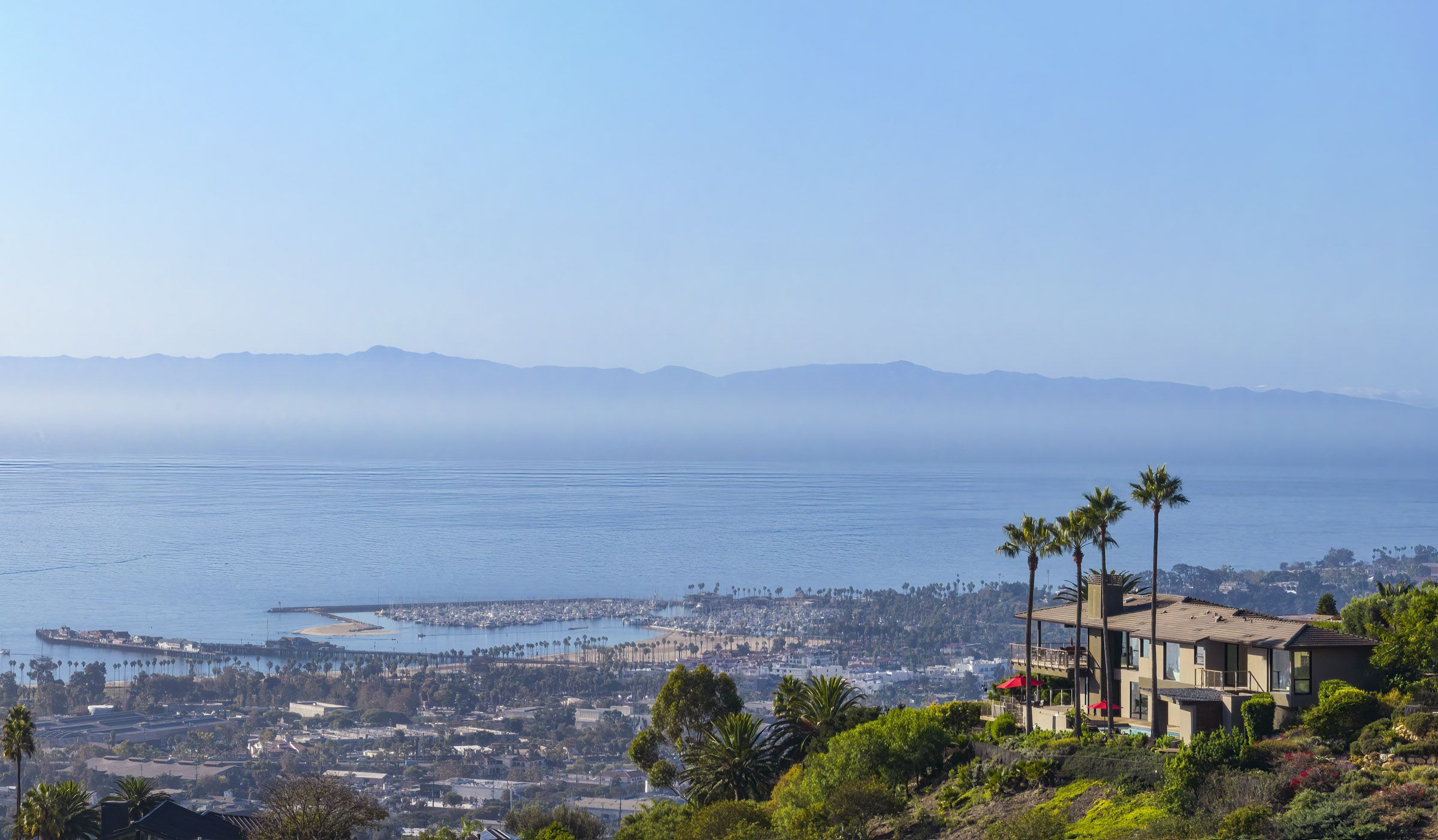 Panoramic view of the ocean and the Channel Islands behind a home perched on a hill.