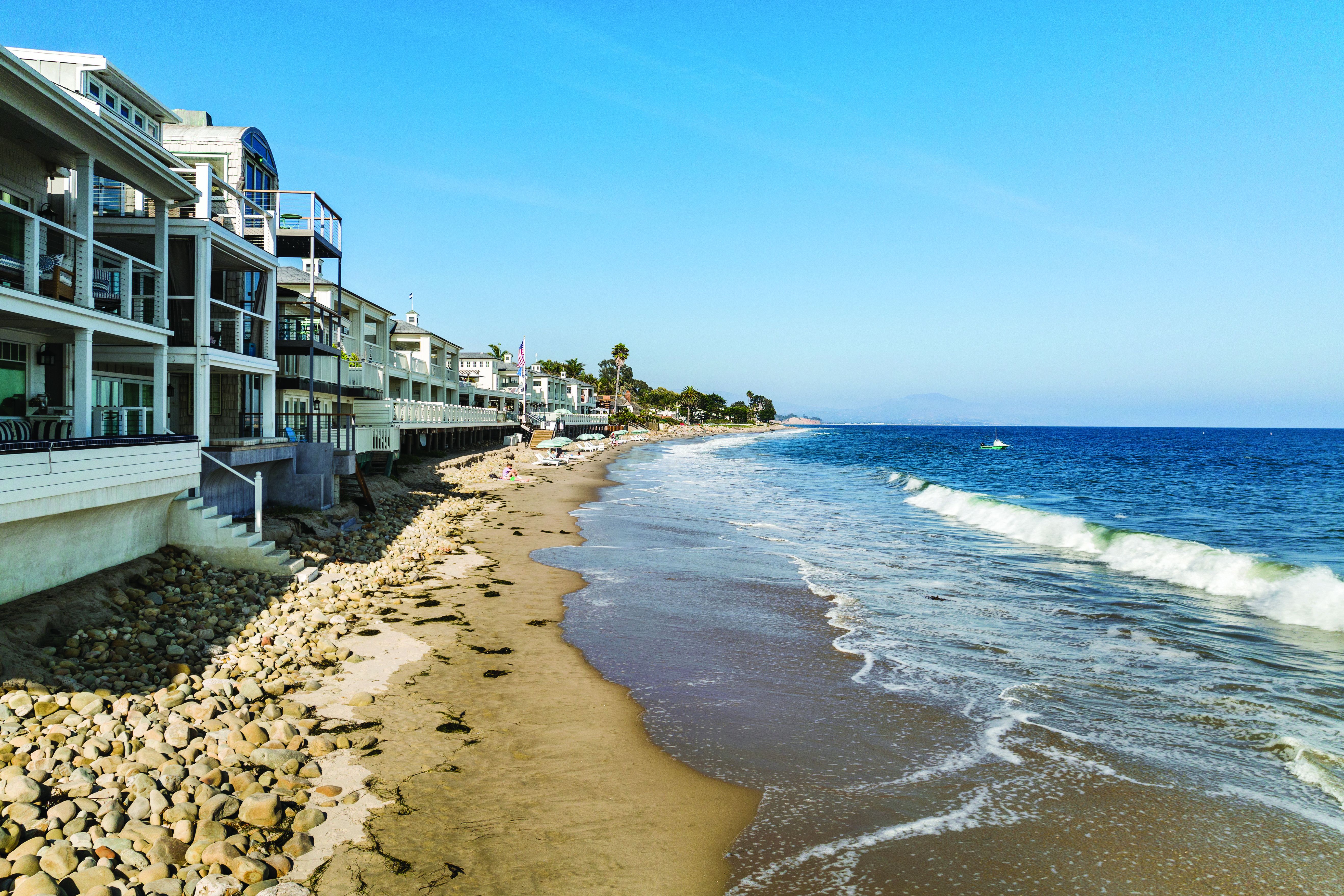 beach homes lining Miramar beach houses, with waves lapping the sand a few steps away