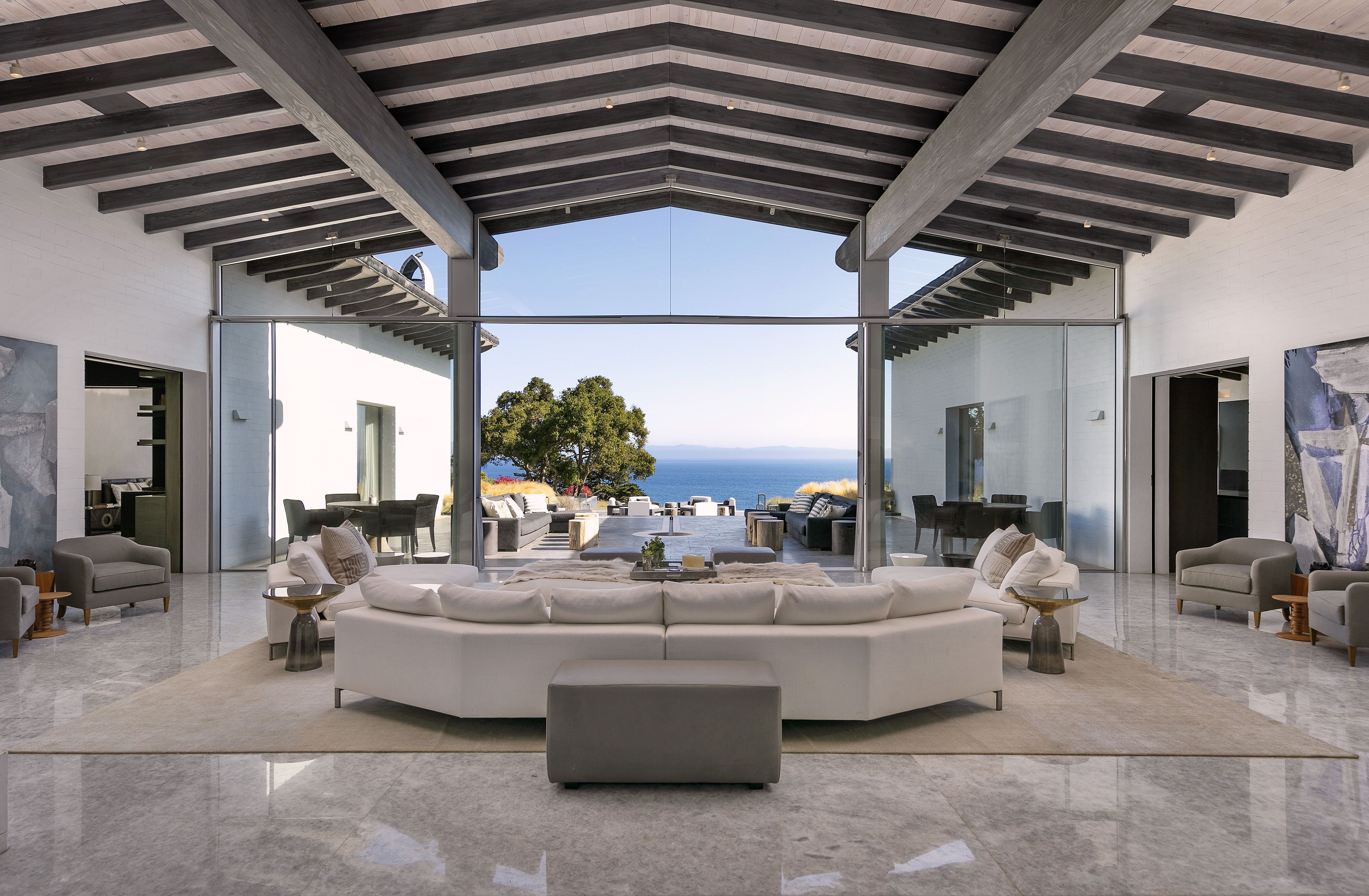 Expansive living room of a Hope Ranch home, with massive beamed cathedral ceiling and wall of glass looking out to the ocean