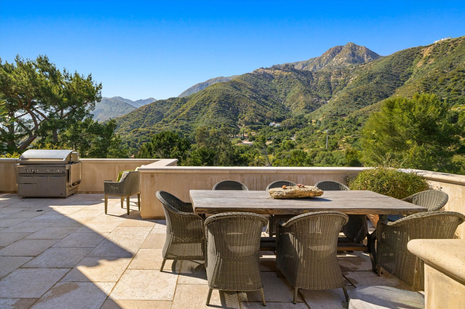 A beautiufl outdoor dining area at a luxury home with views of green rolling hills.