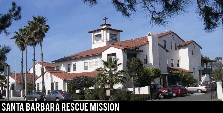 The front of the Santa Barbara Santa Rescue Mission building with its red tiled roof, palm trees and blue sky