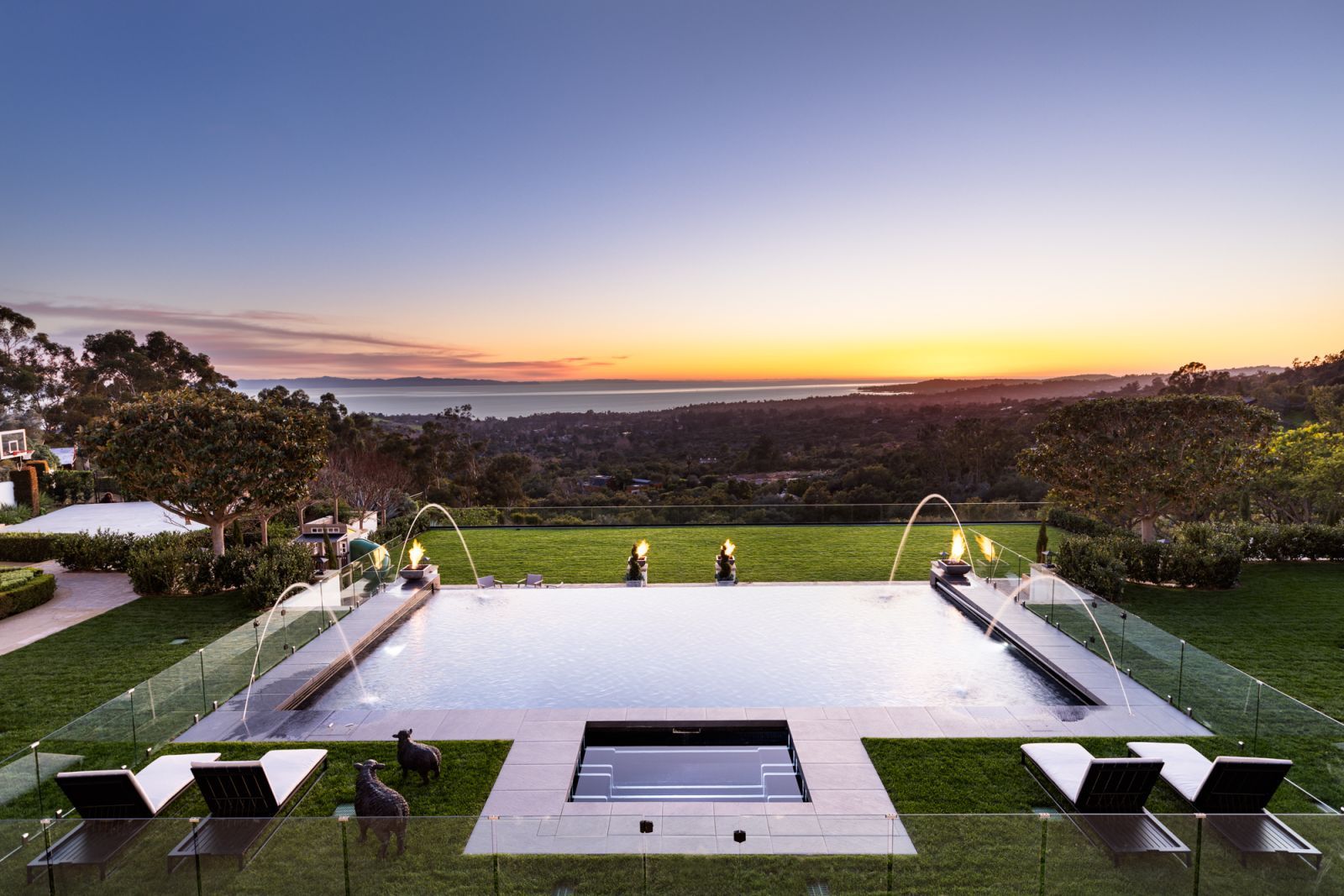 A dramatic infinity-edge pool and spa overlooking the ocean at sunset