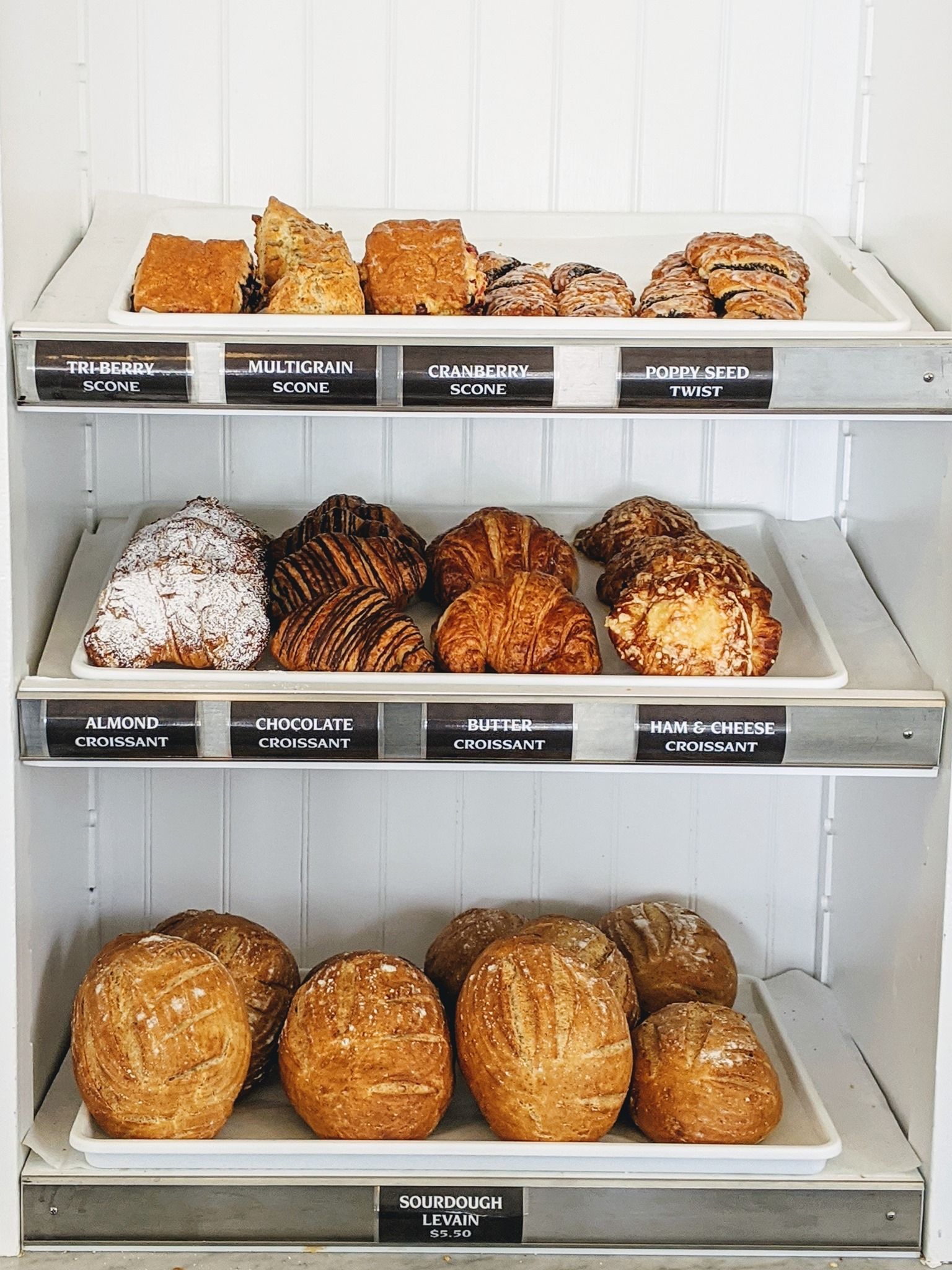 Display trays of fresh baked goods, including croissants and bread