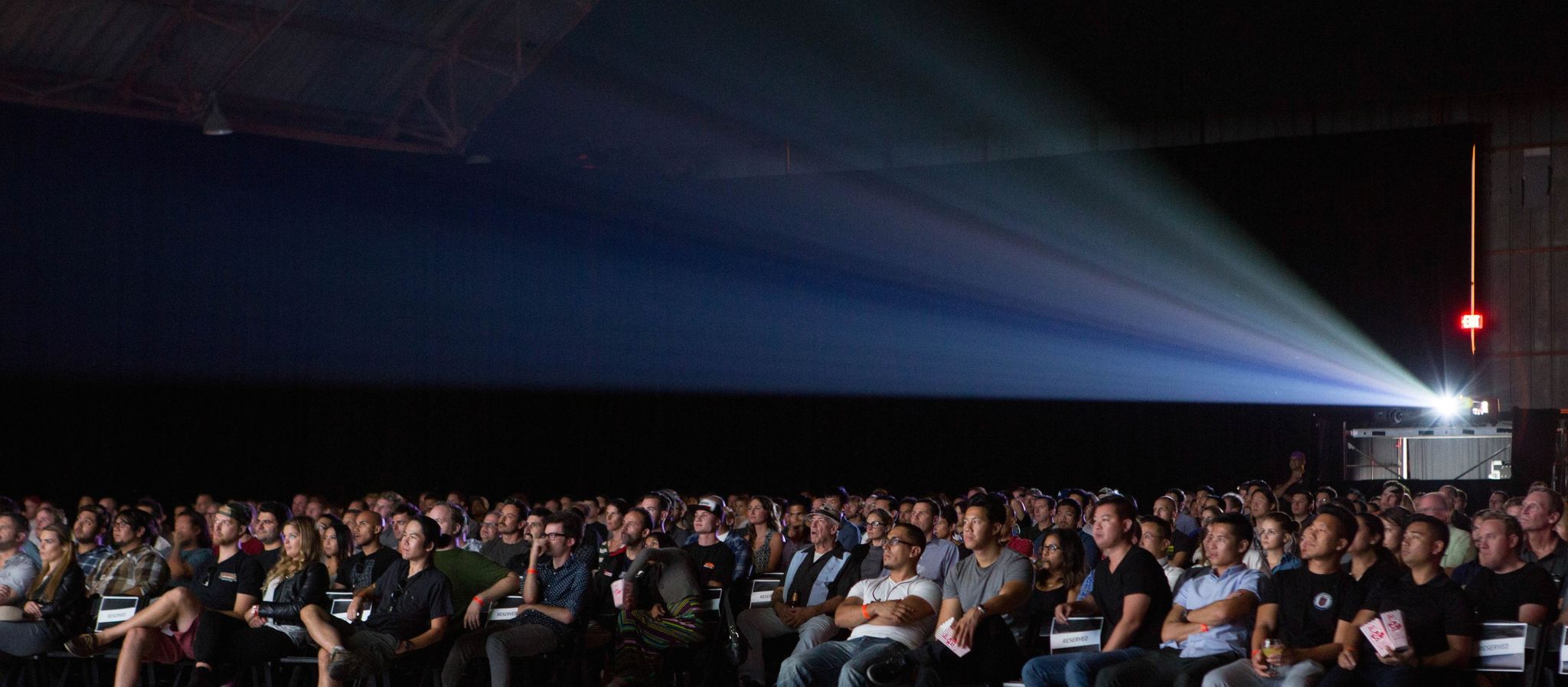 The audience in a dark theater watching a movie