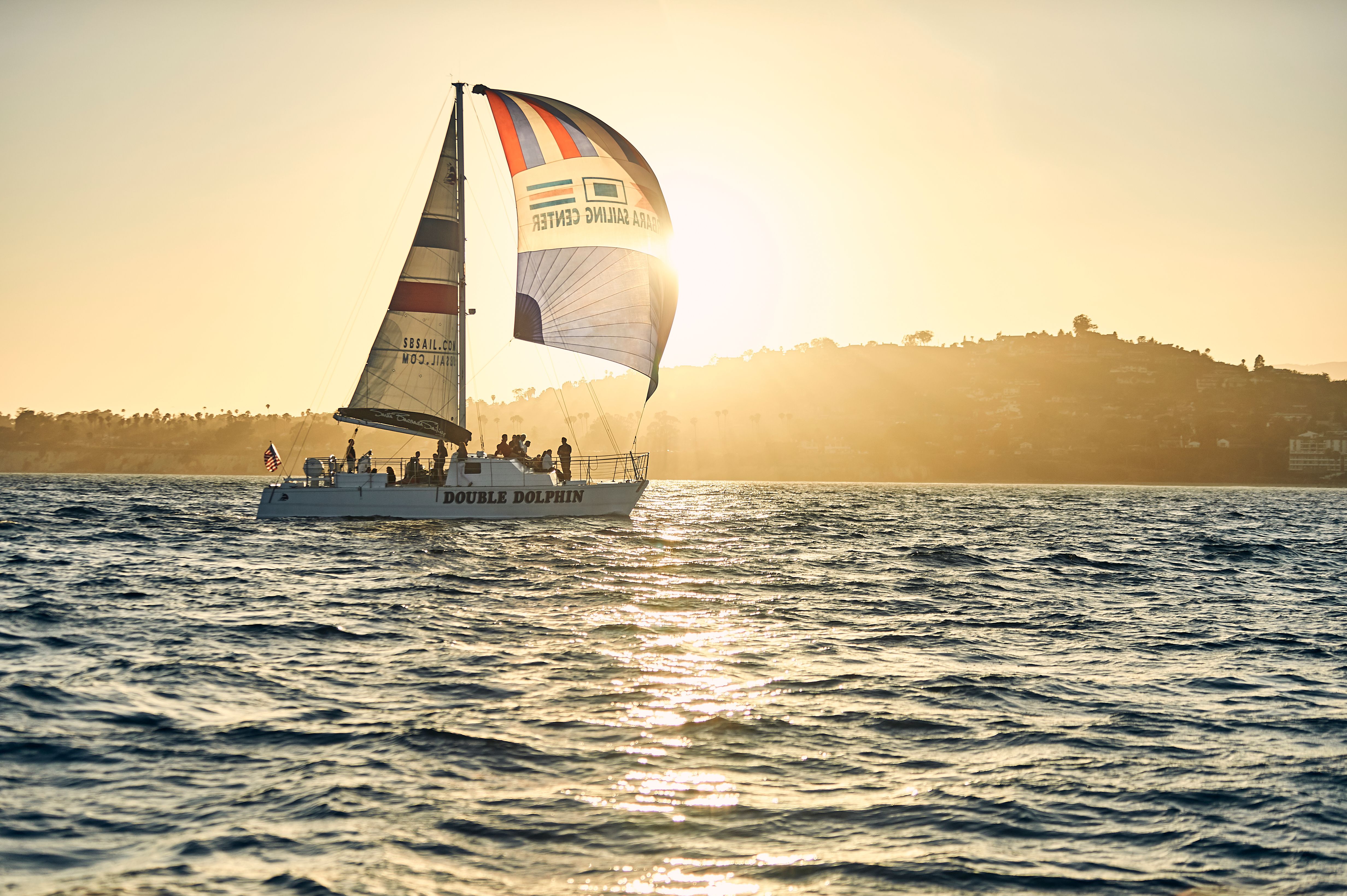 A sunset sail in the Santa Barbara Harbor, with silvery glistening water and an island in the background