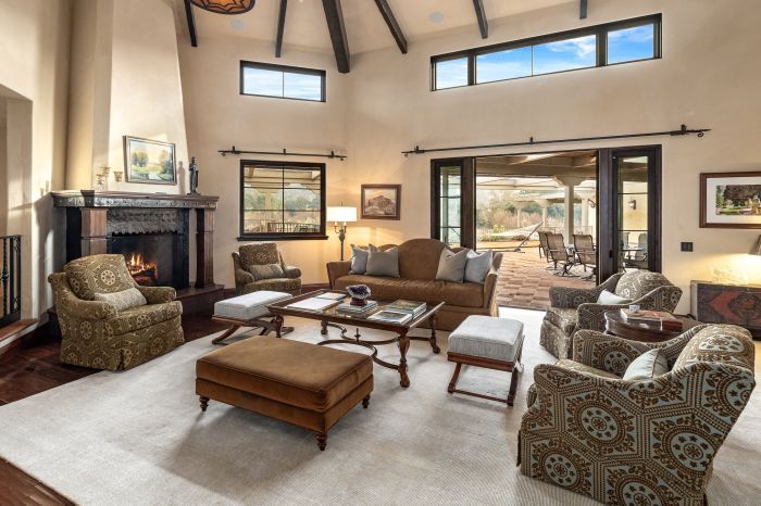 A luxury living room staged to sell with top of the line furniture and a fire in the fireplace.