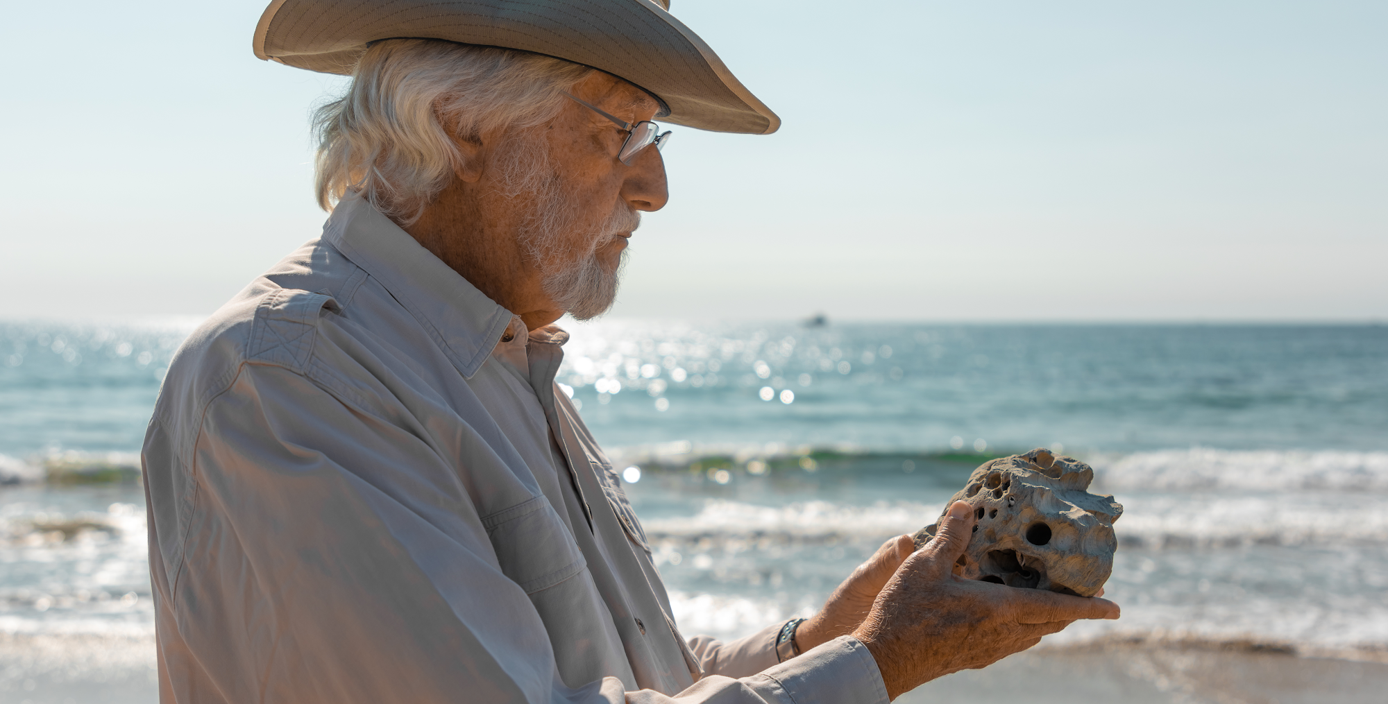 Jean Michelle Cousteau on the beach holding a seashell