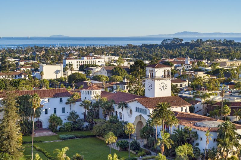 A bird's eye view of the red tile roofed Santa Barbara Courthouse, and beyond to the ocean.