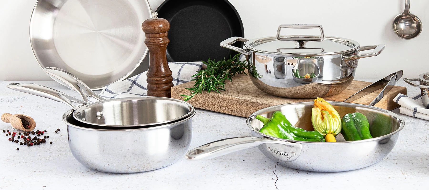 A tabletop display of several high-end stainless steel pots and pans