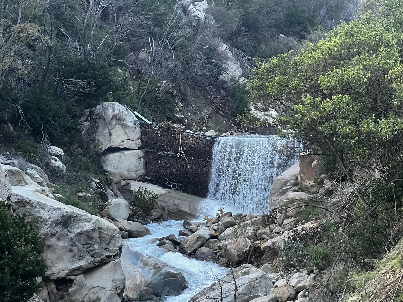 Steel mesh nets capturing debris in a Santa Barbara County creek, but allowing the water to flow in a small waterfall