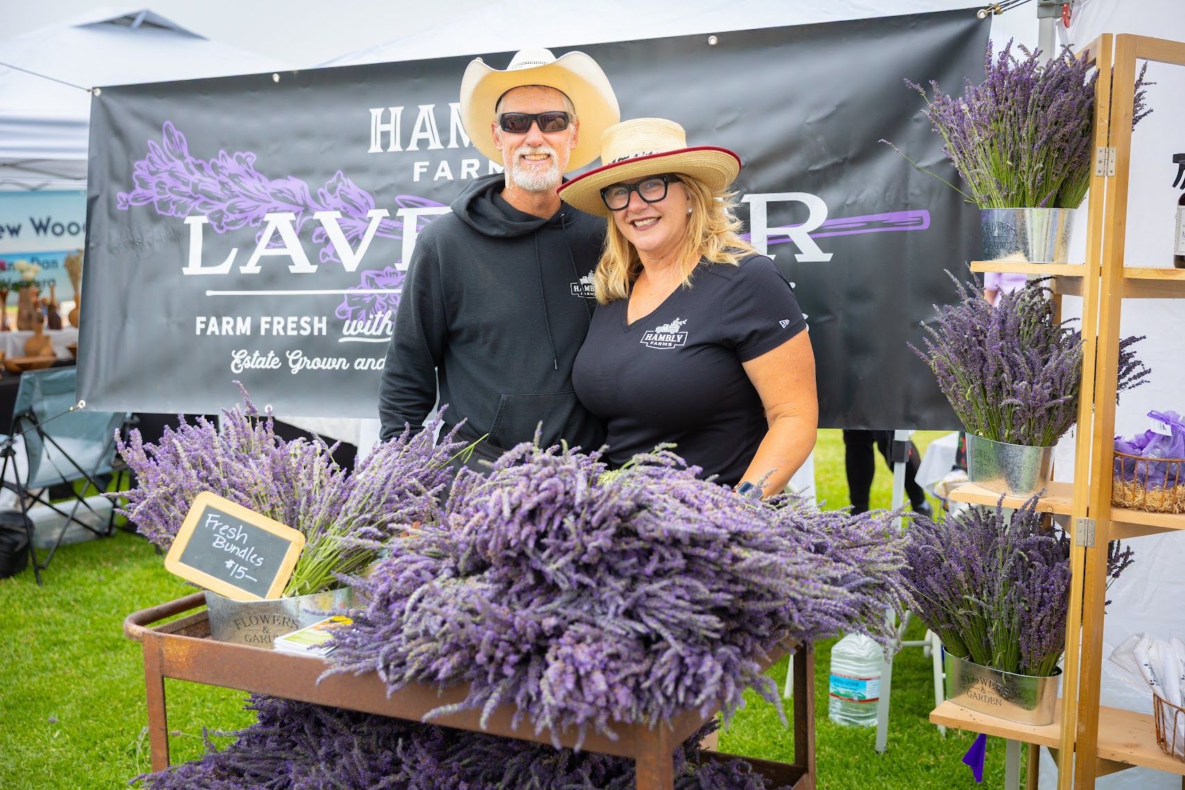 Two growers at the Santa Barbara Lavender Festival in front of bales of the flower.