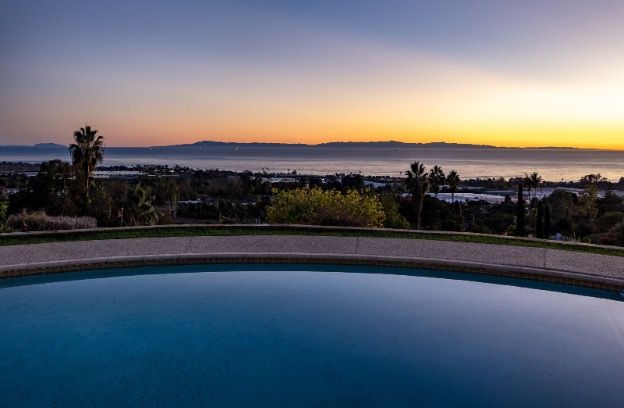Stunning sunset view to the ocean over a luxurious swimming pool