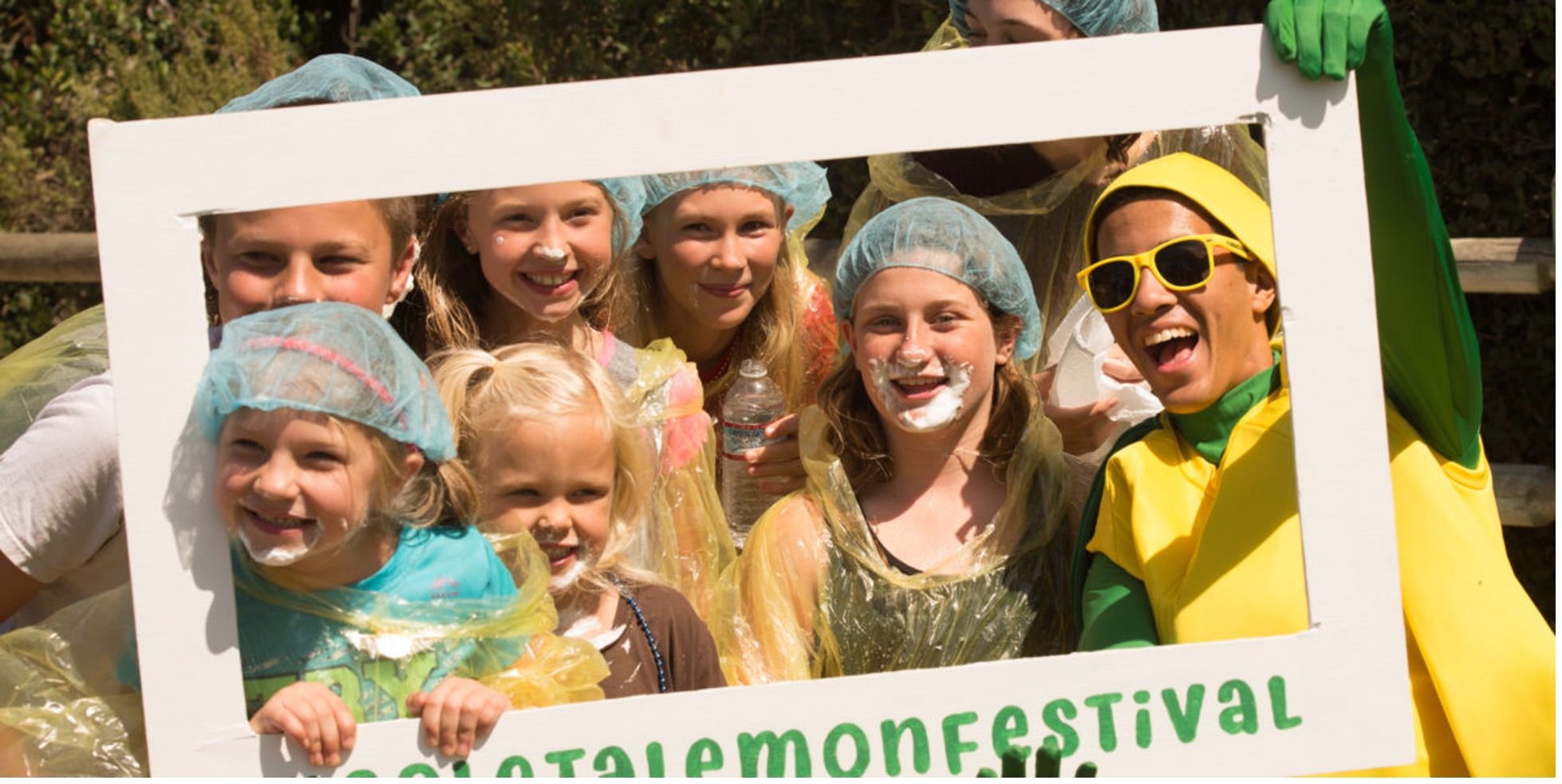 Group of kids with hair nets and whipped cream on their faces celebrating the Goleta Lemon Festival.