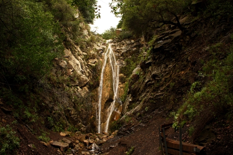 A wall of boulders in a narrow, dark canyon hosts San Ysidro Falls in the mountains above Santa Barbara.