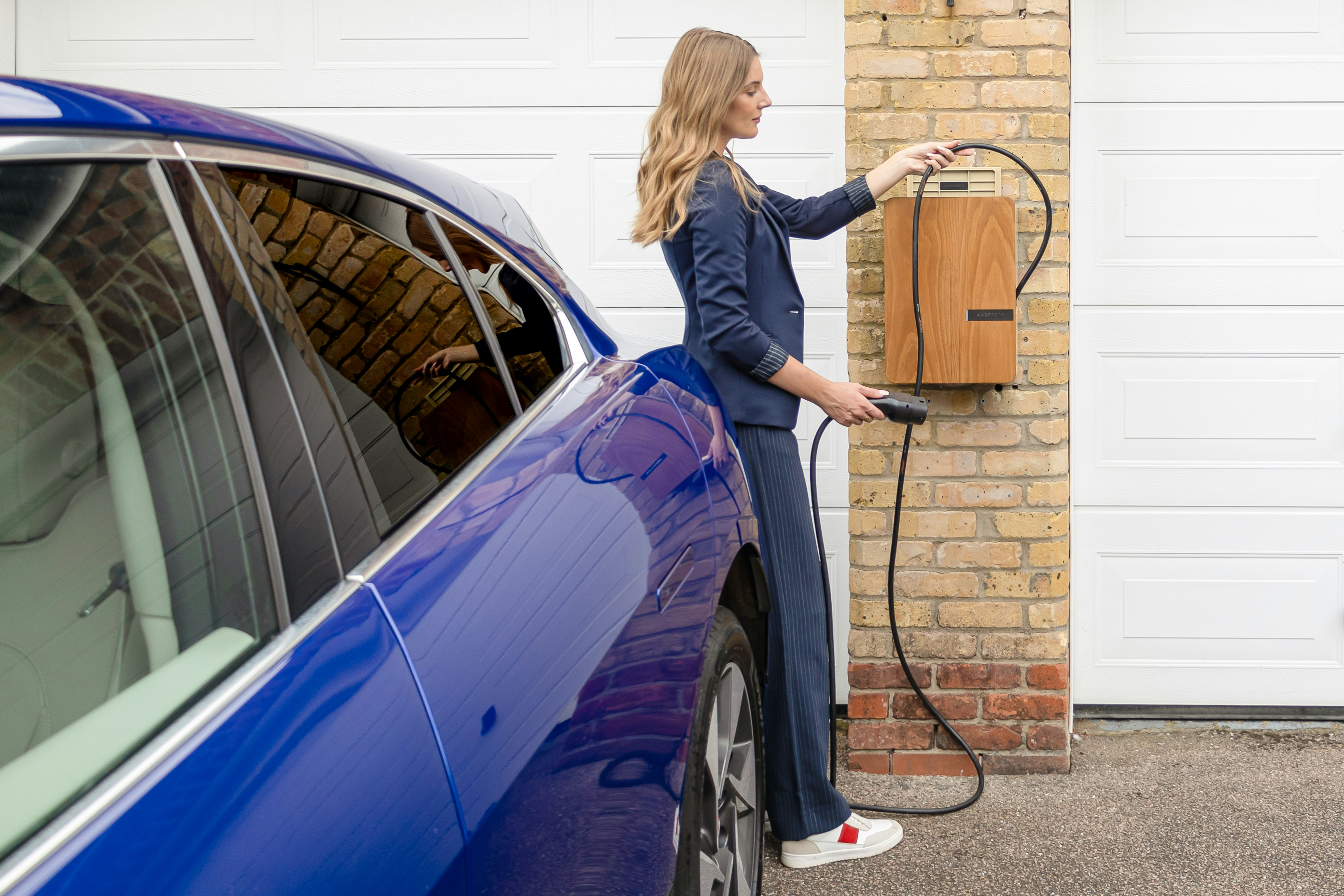 A woman charging her EV at home.