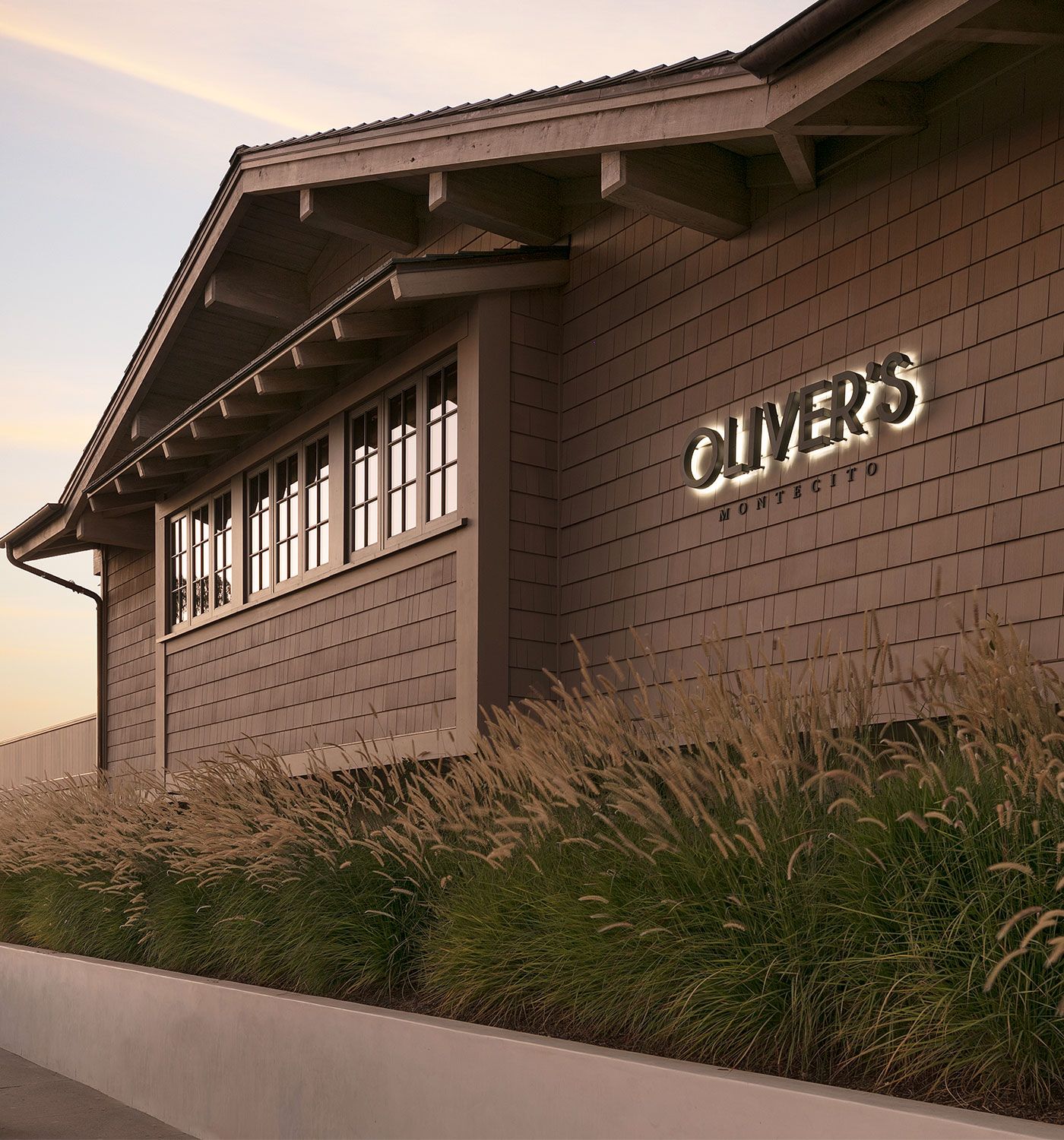 The front of Oliver's restaurant in Santa Barbara: a brown farm style building with shiplap and shake siding